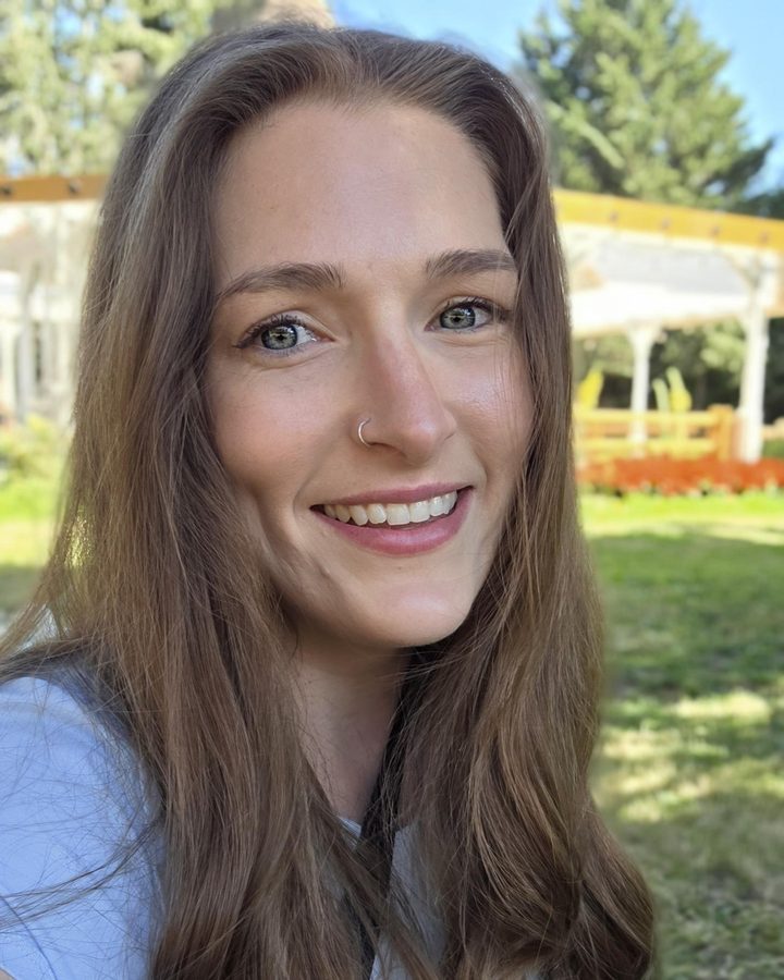 Janelle, the maker behind Golden Tide, smiling in a sunny garden